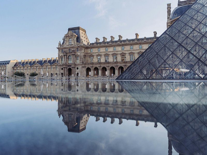 The Louvre pyramid reflected in the still water of its basin